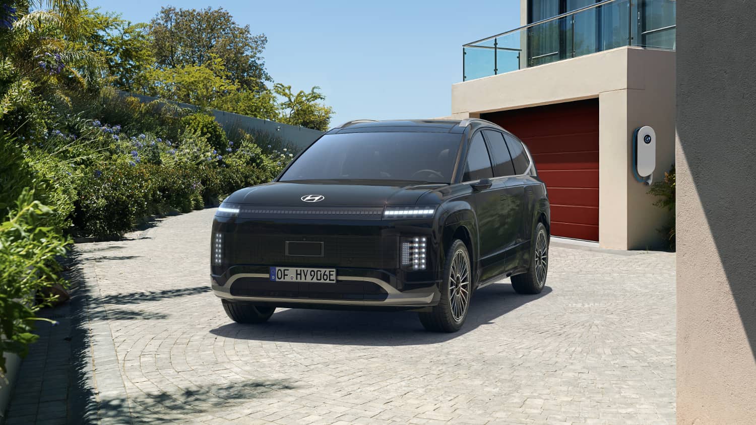 Ein Hyundai IONIQ 9 steht vor einer Garage.