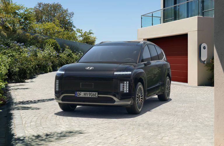 Ein Hyundai IONIQ 9 steht vor einer Garage.